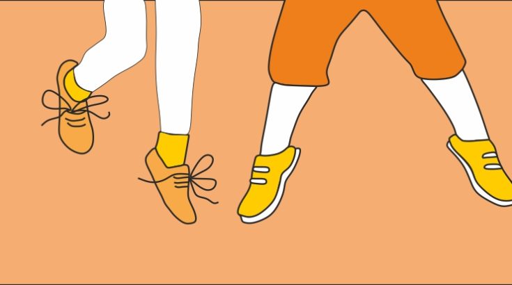 Grafika. Na pomarańczowym tle nogi skaczących chłopca i dziewczynki w pomarańczowych spodenkach i żółtych butach.